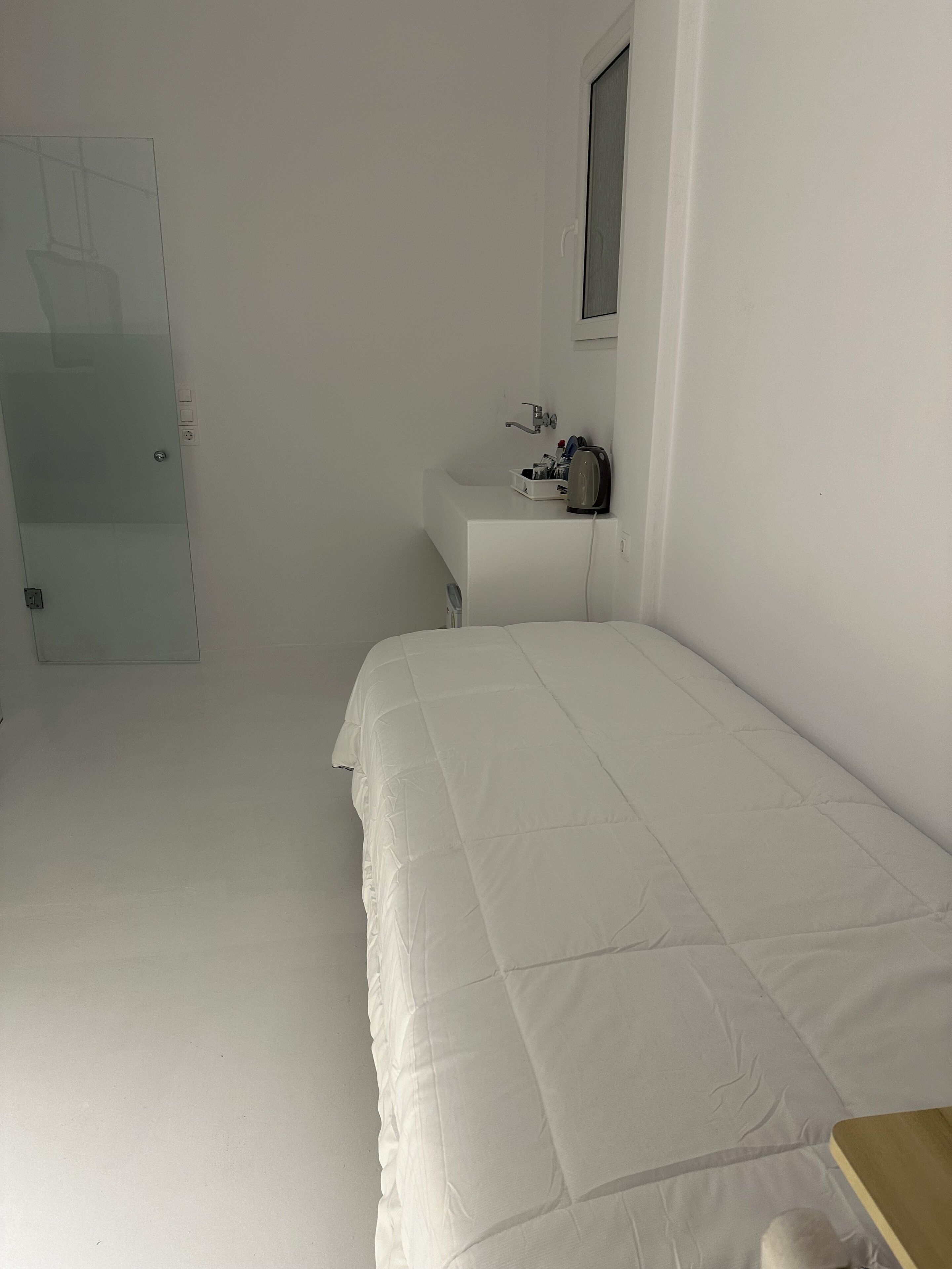 Une chambre à coucher avec un lit, une table de chevet, un miroir et une porte.