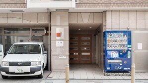 A parking area with a white car and a vending machine. - Apartment Y Legendoal Nipponbashi (Osaka)