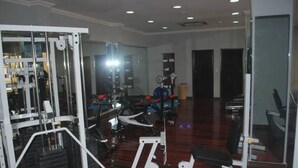 A gym with various exercise equipment, including a treadmill and weight machines. - Greenland Suites (Lagos)