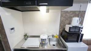 A compact kitchenette with a microwave, toaster, and coffee maker. - Apartment Y Mell Theater Resort (Osaka)