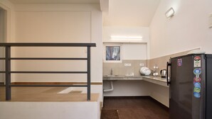 Eine kleine Küche mit einem Kühlschrank, einem Fenster und einem Waschbecken.