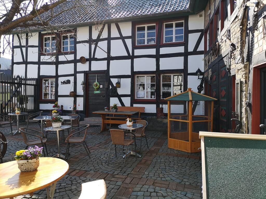 A traditional half-timbered building with outdoor seating and a covered area.