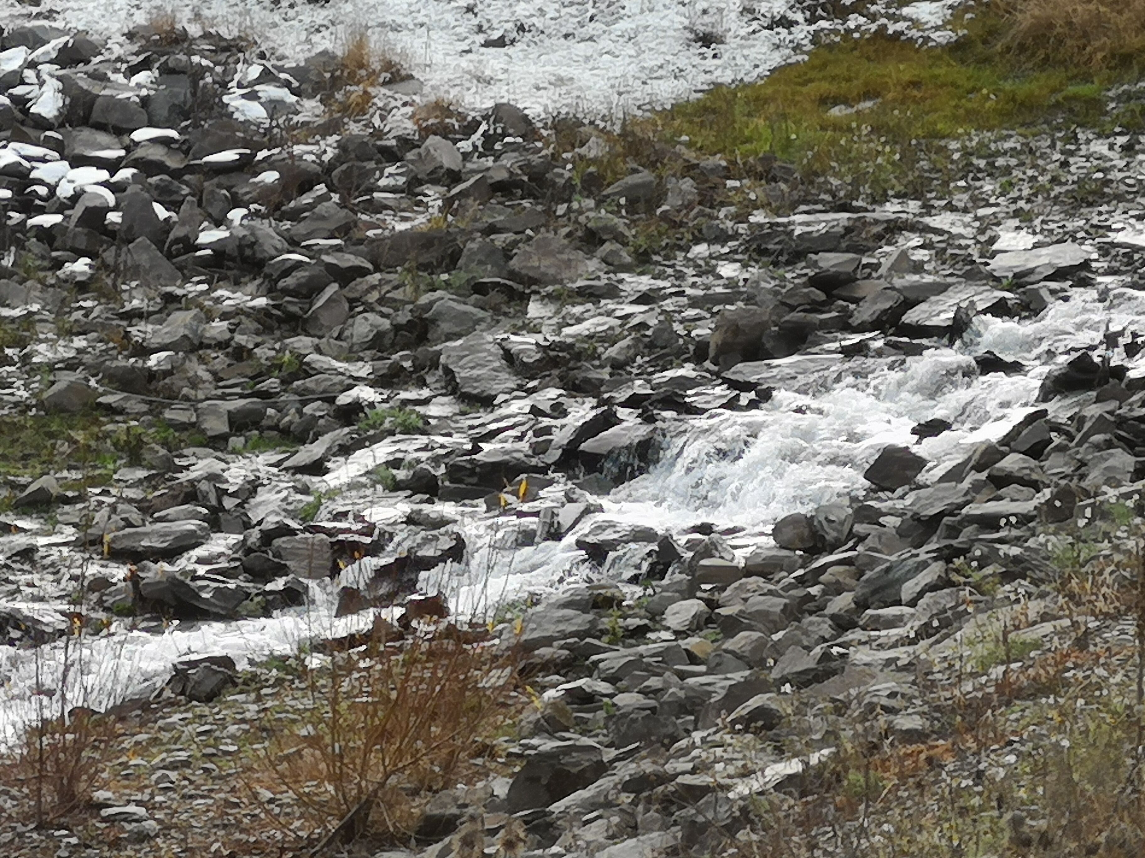 A rocky terrain with a small waterfall.