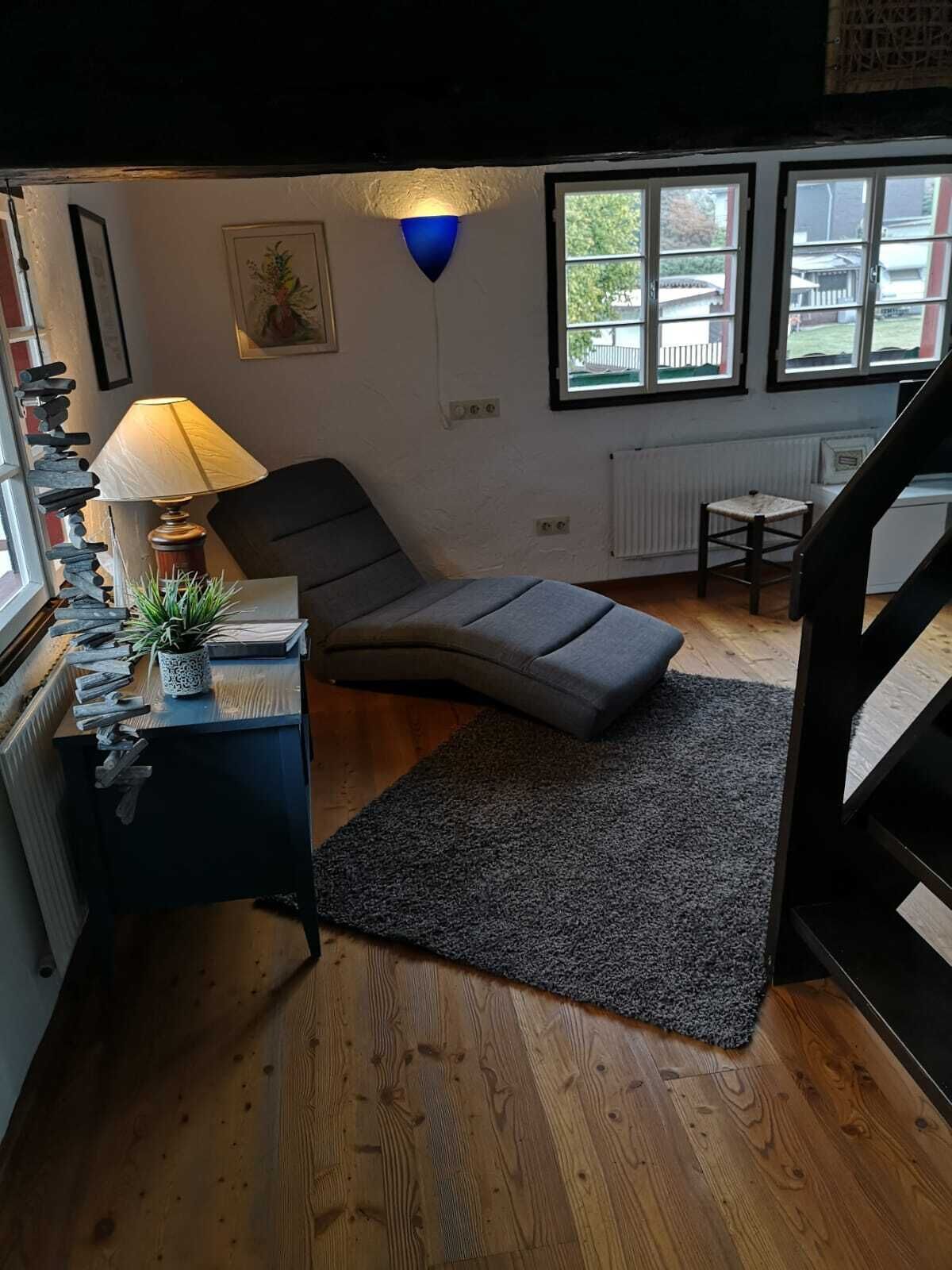Een gezellige kamer met een bed, bureau, lamp en raam.