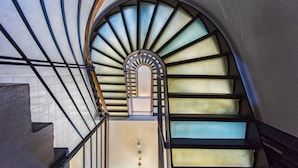 Una escalera moderna con cerramiento de vidrio y barandillas de metal.