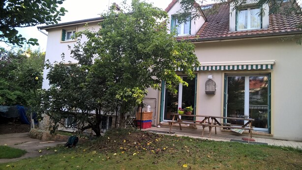 A residential building with a garden, a wooden bench, and a birdcage on the balcony. - Room In A House Full Of Life (Saint-Rémy-lès-Chevreuse)