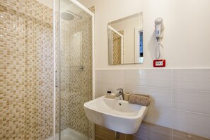 Standaard tweepersoonskamer | Badkamer | Een douche, een haardroger, handdoeken, zeep