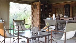Un amplio espacio cubierto con un bar, asientos y un proyector.