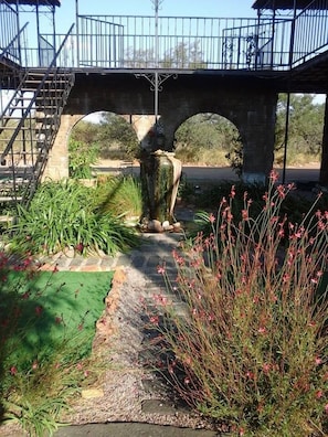 A stone bridge with metal railings and a staircase on the left.