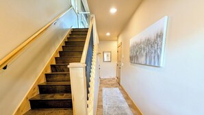 A staircase with wooden steps and a handrail, leading to a landing with a framed picture on the wall. - Modern 3BR Mountain Retreat in North Keystone (Keystone)