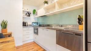 Eine moderne Küche mit weißen Schränken, Edelstahlgeräten und einem eingebauten Geschirrspüler.