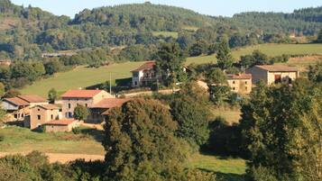 A rural village with stone buildings and a hillside backdrop.