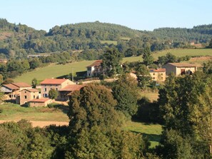 A rural village with stone buildings and a hillside backdrop.
