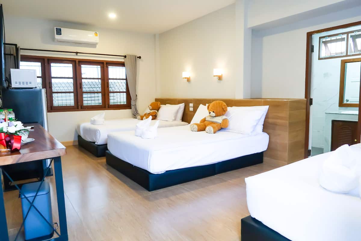 Een hotelkamer met twee bedden, een bureau en een raam met gordijnen.