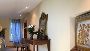 A room with a wooden desk, a chair, a mirror, and a framed painting on the wall. - Domaine de Menerque (Lisle-sur-Tarn)