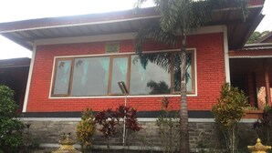 A red brick building with large windows and a balcony. - Villa Sinta (Baturiti)