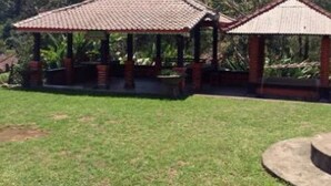 A gazebo with a tiled roof and brick pillars, surrounded by a grassy area and trees. - Villa Sinta (Baturiti)