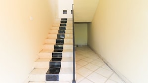 A staircase with alternating black and beige steps leading to a landing. - Bantan Guest House (Tibubeneng)