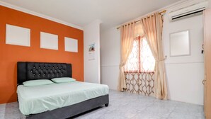 Un dormitorio con cama, aire acondicionado y ventana con cortinas.