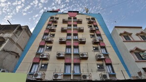 Um edifício de vários andares com varandas e aparelhos de ar condicionado.