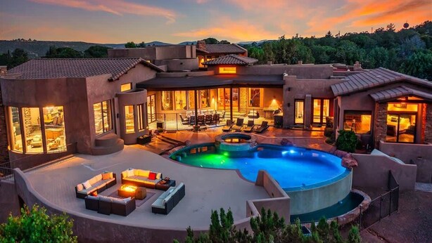 Una casa moderna con piscina, mobiliario exterior y una zona de patio.