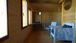A wooden interior with a stone wall, a wooden bench, and a table. - Moulin de la Papeterie Chambres d'hôtes (La Creche)