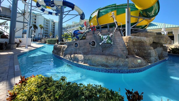 A water park with a pool, slides, and a pirate-themed play area.