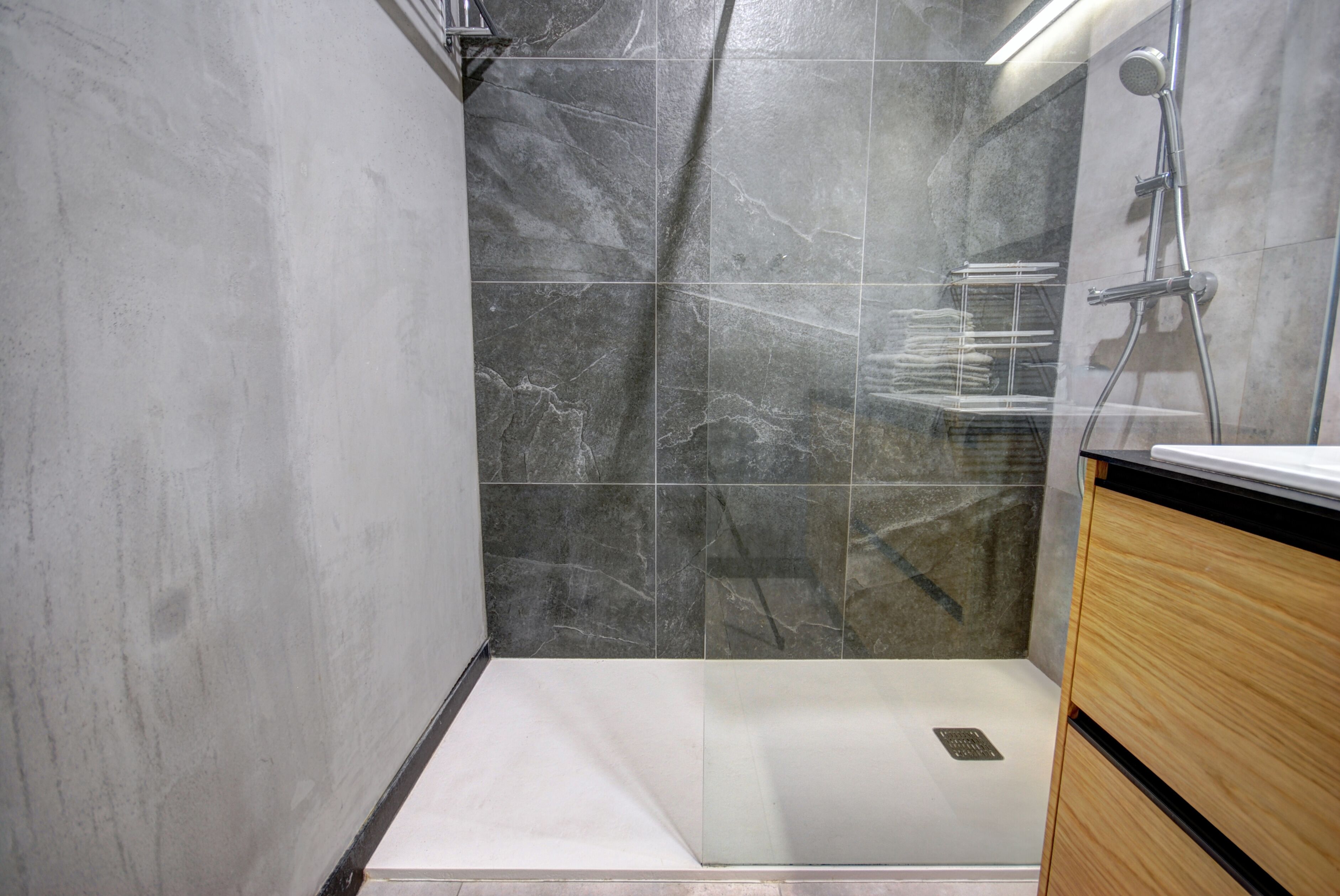 A modern bathroom with a shower, a toilet, and a sink.