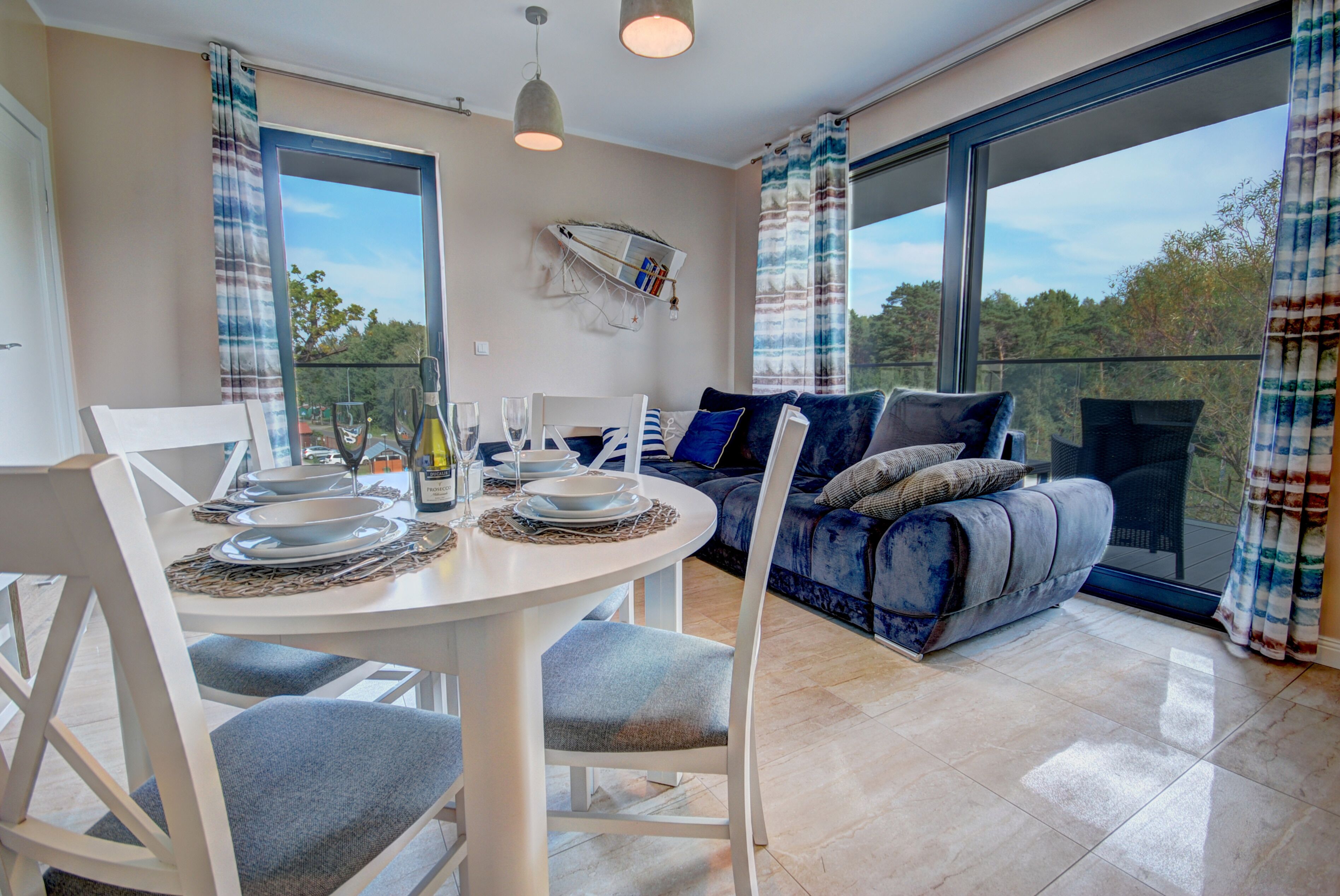A modern living room with a sofa and a dining table set for four.