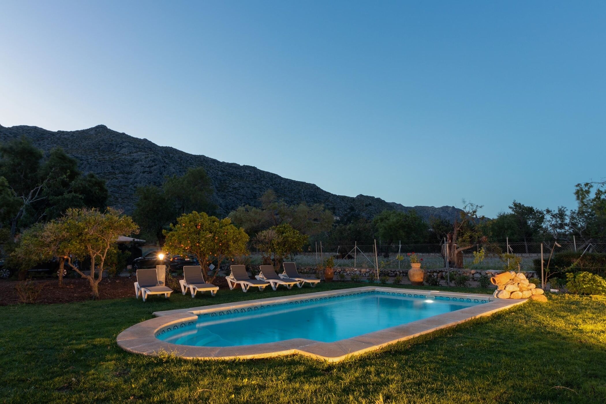 Une piscine avec des chaises longues et une vue sur les montagnes en arrière-plan.