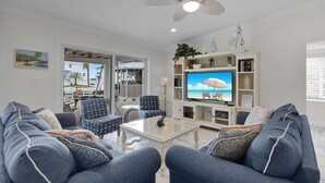 A living room with a TV, two sofas, a coffee table, and a ceiling fan. - The Good Life 5bed/4bath wth private pool 30 ft of dock and 2 kayaks included (Marathon)