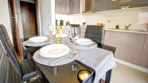 A dining area with a table set for four, including plates, glasses, and cutlery. - HelApart - Apartamenty Foka (Hel)