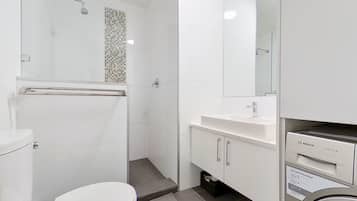 Ein modernes Badezimmer mit Dusche, Toilette und einer Bosch Waschmaschine.