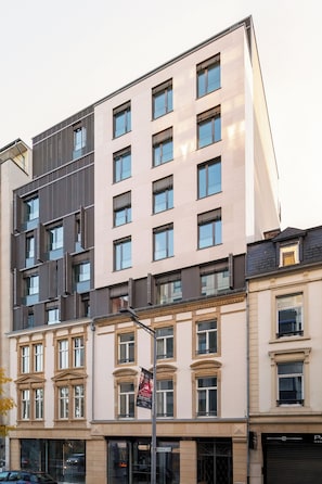A multi-story building with a mix of modern and classical architectural styles, featuring large windows and a prominent entrance.