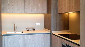 A modern kitchen with wooden cabinets, a stainless steel sink, and an oven.