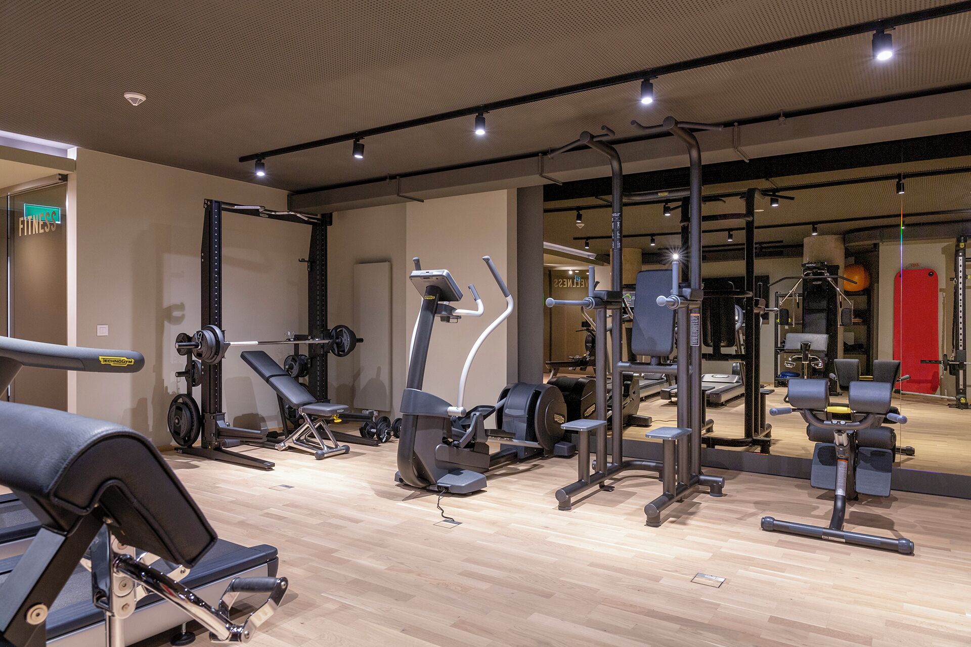 A modern gym with various exercise equipment, including treadmills, weight machines, and free weights.