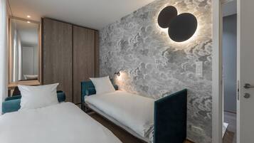 Un dormitorio moderno con dos camas, un espejo grande y una pared texturizada con una lámpara en forma de corazón.