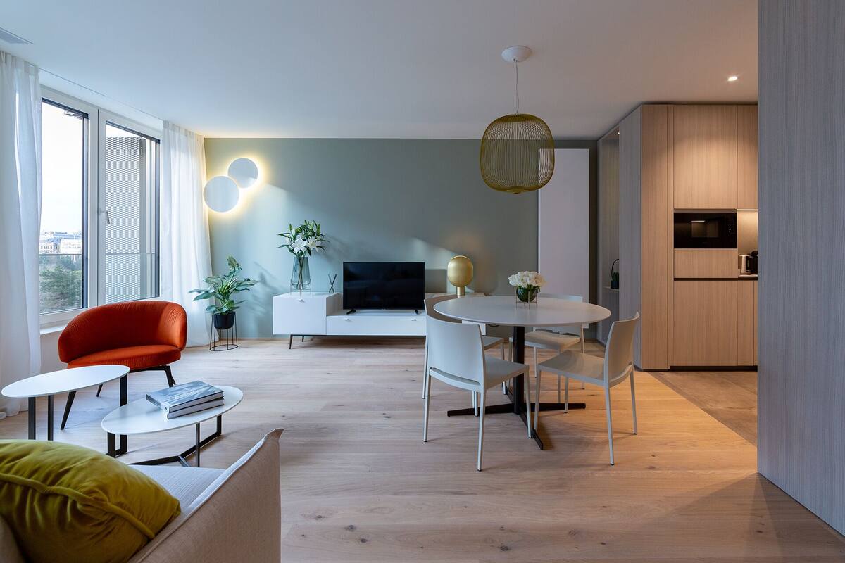 Un salon moderne comprenant un canapé, une table à manger et un coin cuisine.
