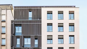 A multi-story building with a mix of modern and classical architectural styles, featuring large windows and a prominent entrance. - The Central City - Luxury ApartHotel (Luxembourg City)