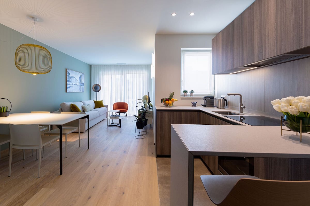 Une cuisine moderne avec des meubles en bois, un îlot central intégré et une grande fenêtre.