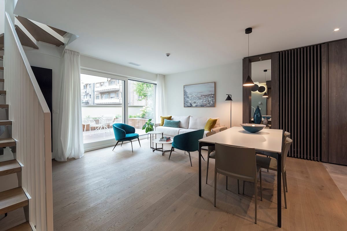 Un salon moderne avec un coin repas, un plancher en bois et un escalier.