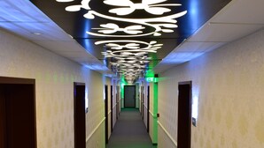 A hotel hallway with a modern ceiling design, a central corridor, and doors on both sides. - Hotel Forum (Ploiesti)