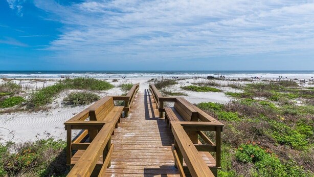 A wooden boardwalk leading to a beach with sand dunes and sparse vegetation. - Island Oasis l Steps to the Ocean l 2 Pools (St. Augustine)