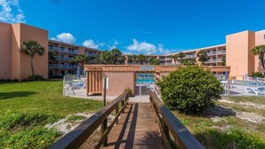 A hotel with a pool area, a wooden walkway, and a sign indicating private property. - Island Oasis l Steps to the Ocean l 2 Pools (St. Augustine)
