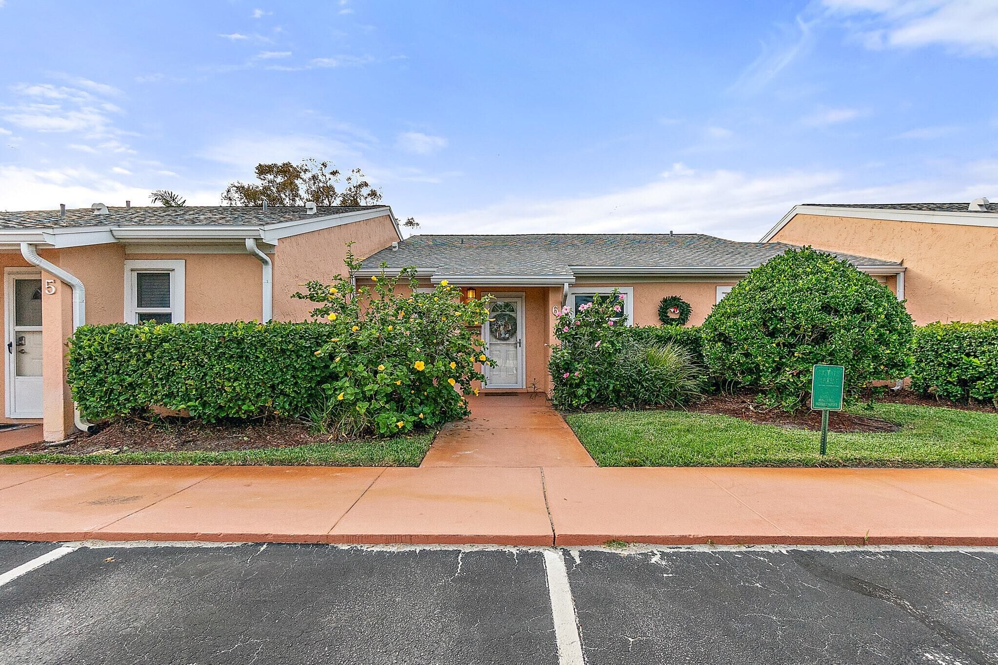 A residential building with a front entrance, a driveway, and a parking lot.