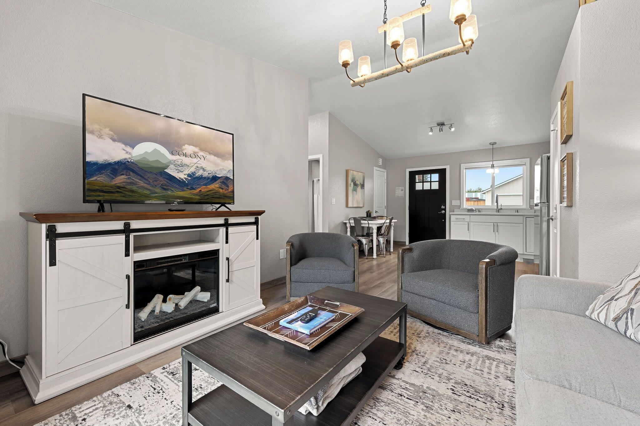 A living room with a fireplace, a television, and a dining area.