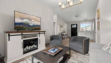 A living room with a fireplace, a television, and a dining area.