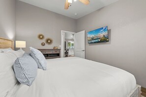 A bedroom with a large bed, a nightstand, a lamp, and a wall-mounted picture. - Mt. Views • Downtown Walkable • Kitchen • Laundry! (Palmer)
