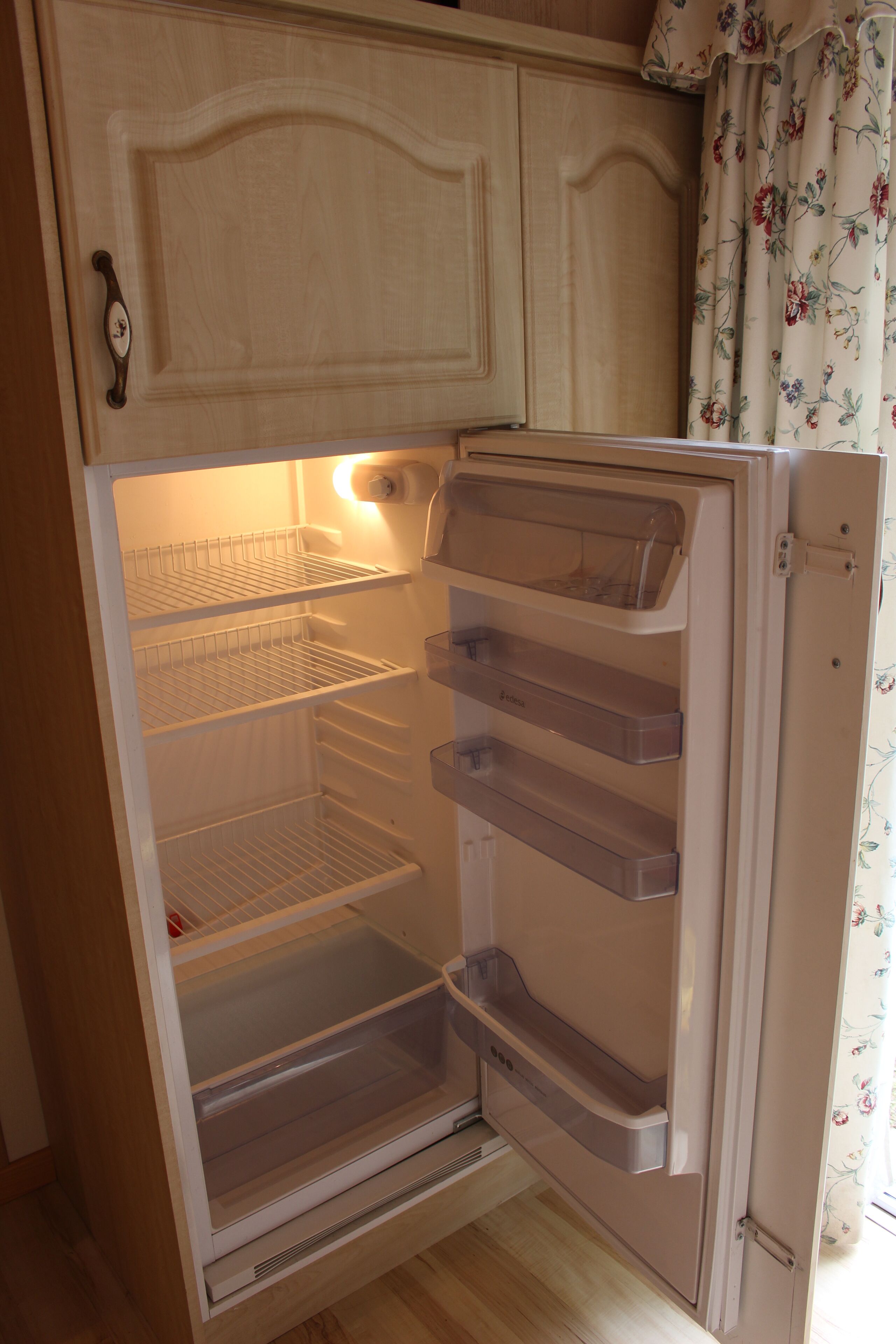 An open refrigerator with multiple shelves and a freezer compartment.