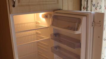 An open refrigerator with multiple shelves and a freezer compartment.